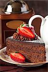 Delicious chocolate cake with cream and berries on a dark background.