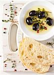 Olive oil with olives and spices. Delicious dip and fresh bread ciabatta.