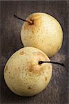 two asian ripe yellow pears on old wooden table, selective focus