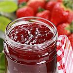 Homemade strawberry jam in a jar, decorated with fresh strawberries