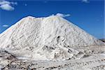 Big pile of freshly mined salt, set against a blue sky