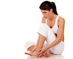 brunette holding her feet on white isolated background