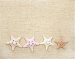 Background with starfishes on canvas texture