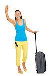 Full length portrait of happy young tourist woman with wheel bag saluting
