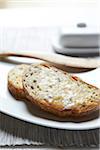 Close-up of Buttered Multigrain Toast with Wooden Knife, Studio Shot