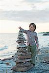 Boy on beach stacking rocks