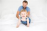Happy little girl with father in bed