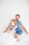 Happy little girl with father in bed