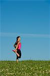 Woman stretching in meadow