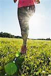 Low section of woman jogging in meadow