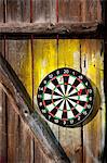 Dart-board hanging on wooden wall