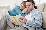 Couple On Sofa, Man Reading Book