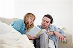 Couple On Sofa Reading Book