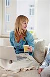 Couple On Sofa, Woman Using Laptop