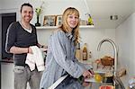 Couple Washing Up In Kitchen