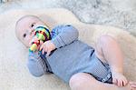 Baby boy playing with rattle, Munich, Bavaria, Germany