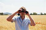 Man On Field Looking Through Binoculars, Croatia, Dalmatia, Europe