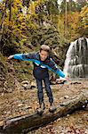 Boy Walking On Tree Trunk In Forest, Bavaria, Germany, Europe