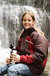 Girl With Thermos Bottle In Front Of A Waterfall, Bavaria, Germany, Europe