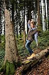 Boy Balancing On Tree Trunk In Forest, Bavaria, Germany, Europe