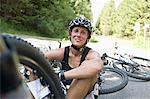 Female Bicyclist Sitting On Road, Sonthofen, Schattwald, Bavaria, Germany