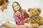 Girl is using playfully a stethoscope on a teddy bear, Osijek, Croatia