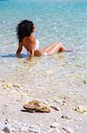 Young woman sitting in shallow water, Dugi Otok, Dalmatia, Croatia