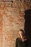 Young woman in front of brick wall, portrait