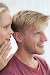 Woman whispering in man's ear
