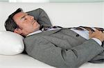 Mature businessman sleeping on couch