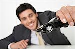 Mid-adult businessman playing with toy car