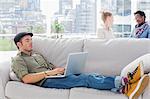 Worker using his laptop while laying on a couch