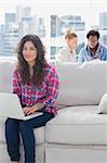 Attractive worker using laptop while sitting on a couch