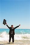 Businessman in the sea raising his arms