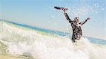 Businessman raising his briefcase in the sea