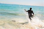 Businessman running into the sea