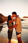 Young couple embracing and kissing each other on the beach