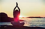 Woman doing yoga on a beach