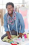 Smiling fashion designer working on a green textile