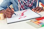 Artistic man drawing clothes in his studio