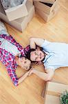 Young couple lying on the wooden floor