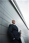 Portrait of businessman leaning against wall of building, Mannheim, Germany