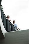 Mature businessmen standing on outdoor balcony, talking