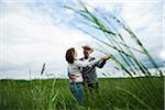 Mature couple dancing in field of grass, Germany