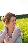 Portrait of teenage girl sitting in field, Germany