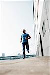 Mature man running along loading dock in front of warehouse, Mannheim, Germany