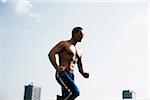 Mature man running against blue sky, Mannheim, Germany