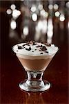 closeup of a mini chocolate martini glass layered with dark and milk chocolate with chocolate shavings on top