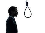 one caucasian business man portrait profile standing  in front of hangman's noose in silhouette studio isolated on white background