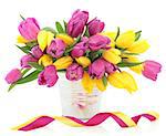 Pink and yellow tulip flower arrangement in a metal vase with ribbons over white background.